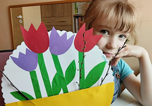 Dziewczynka prezentuje zrobione kwiaty.