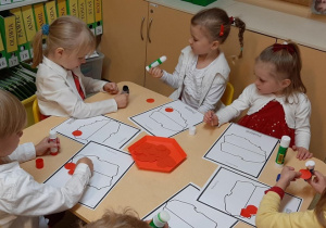 Dzieci z grupy 5 wyklejają kontury Polski.