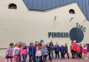 Dzieci stoją pod teatrem Pinokio.