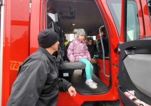 Dzieci zwiedzają wóz strażacki.