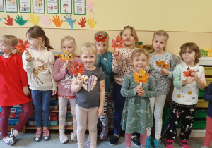 Dzieci prezentują kukiełki wykonane z liści.