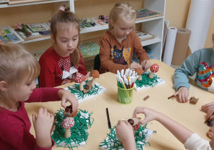 Dzieci wykonują grzyby z pietruszki i ziemniaka.