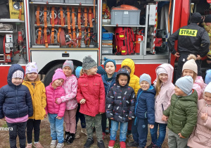 Dzieci oglądają wóź strażacki.