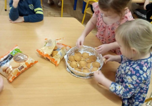 Dzieci układają ciasteczka w foremce.