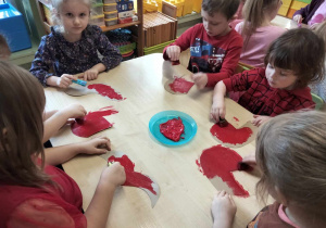 Dzieci malują farbą serca.