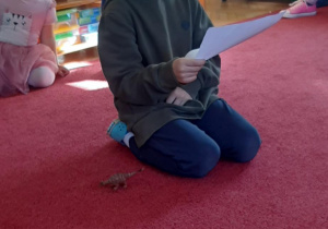 Chłopiec wymyśla historię o dinozaurze.
