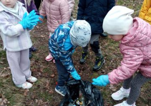Dzieci sprzątają teren wokół przedszkola w ramach akcji "Galante sprzątanie"
