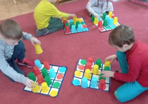 Kodowanka /przesuwanka - dzieci układają kolorowe kubeczki według koloru.