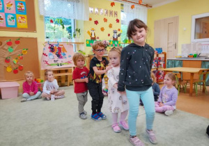 Dzieci tańczą w sali przedszkolnej.