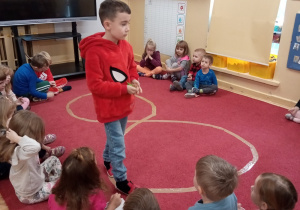 Spacer z rekwizytem po naklejonej na dywanie taśmie tworzącej kształt cyfry 8.