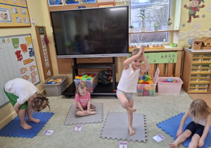 Dzieci wykonują ćwiczenia z wykorzystaniem kart jogi.