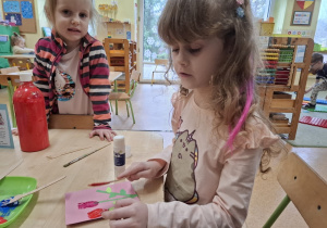 Dziewczynka wykonuje kartę na Dzień Kobiet.