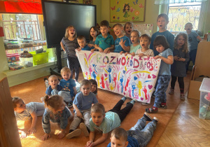 Grupa prezentuje plakat z okazji dnia autyzmu.