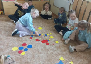 Dziewczynka segreguje figury geometryczne.