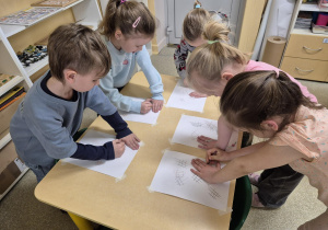 Dzieci 6 letnie zgodnie z systemem Edukacja przez ruch rysują kratki przy dłonie.