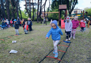 Dzieci rywalizują ze sobą podczas Dnia Sportu pokonując tor przeszkód  .