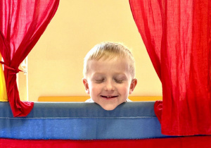 Chłopiec odgrywa rolę w teatrzyku.