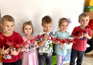 Dzieci prezentują zrobiony czerwony łańcuch.