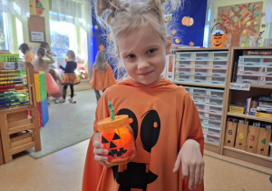 Dziewczynka prezentuje swój dyniowy lampion.