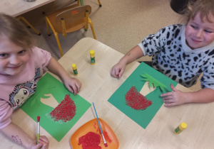 Dziewczynki malują farbami muchomory.