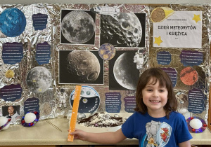 Dziewczynka przy tablicy opowiada o księżycu.