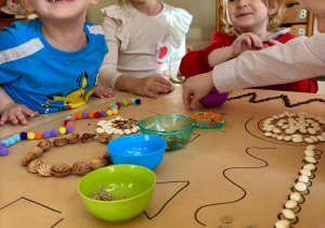 Dzieci układają wzory z nasion.