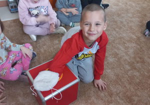 Chłopiec losuje wróżbę podczas andrzejkowych wróżb.