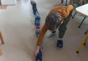 Dzieci układają buty podczas andrzejkowych wróżb.