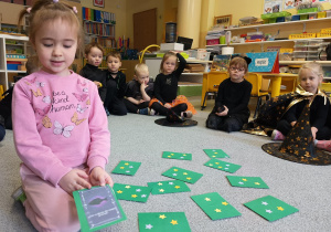 Dziewczynka losuje kartę z wróżbą.
