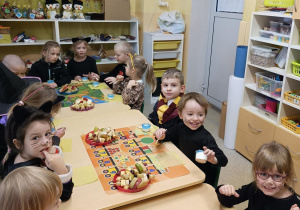 Dzieci spożywają andrzejkowy poczęstunek przygotowany przez rodziców.