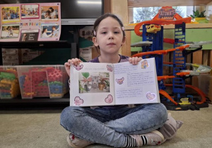 Dziewczynka omawia prace w albumie Tusi.