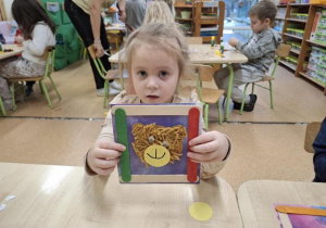 Dziewczynka prezentuje pracę plastyczną: misia.