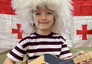 Chłopiec pozuje z gruzińskim instrumentem.