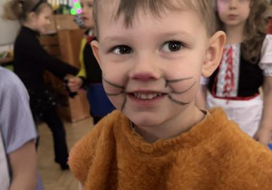 Chłopiec uśmiecha się na balu karnawałowym.