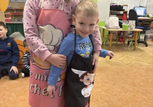 Dzieci dyżurni pokazują swoje fartuszki.