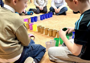 Chłopcy budują z kubeczków.