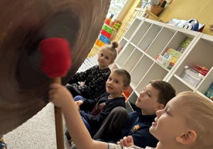 Chłopiec uderza w gong.