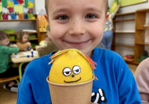 Chłopiec pokazuje pacynkę z cytryny.