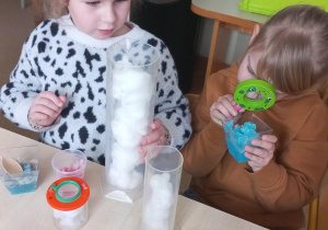 Dziewczynki badają właściwości śniegu.