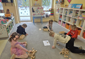 Dzieci układają literą a z klocków.