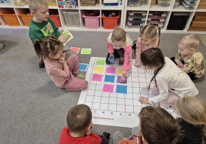 Dzieci układają płytki i programują Robota Indi.