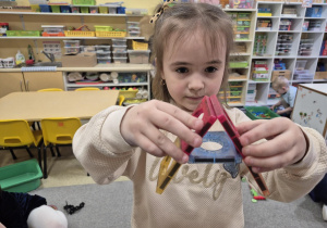 Dziewczynka prezentuje literkę A zbudowaną z klocków.