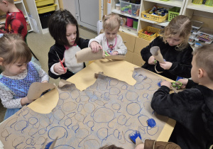 Dzieci wycinają pokolorowane kółka.