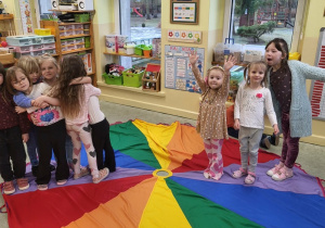 Dzieci uczą się kolorów na chuście animacyjnej.