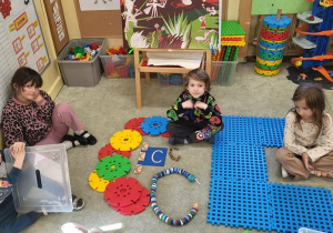 Dzieci wykonują literę C z klocków, sznurka, korków.