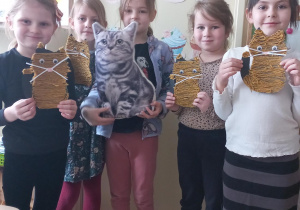 Dzieci prezentują swoje prace plastyczne - koty wykonane z okazji - Dnia Kota.