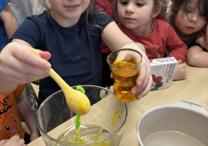 Dzieci barwią wodę barwnikiem.