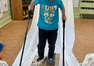 Chłopiec naśladuje narciarza.