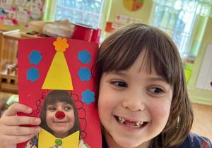 Dziewczynka pokazuje swoją pracę.