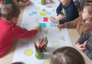 Dzieci kolorują figury geometryczne.